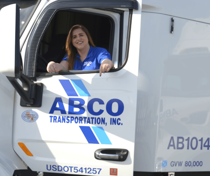 Female truck driver in an ABCO transportation truck