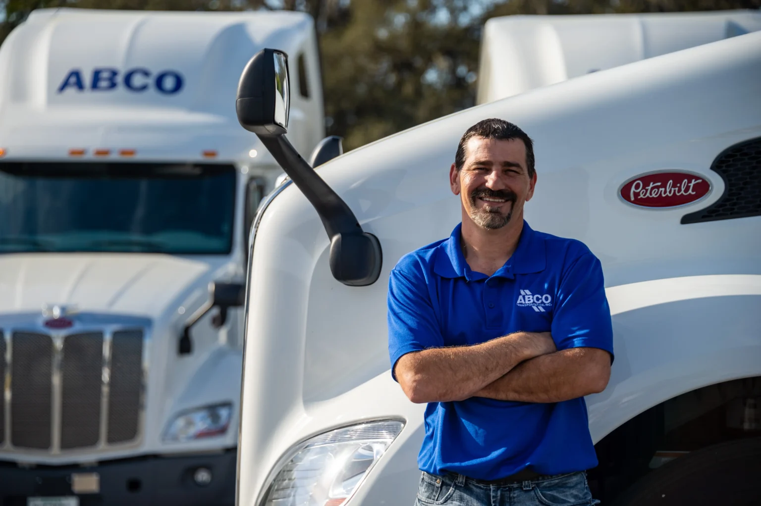ABCO company driver standing in front of ABCO trucks